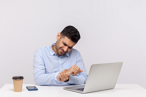 Tolleson Employee Working in Phoenix AZ Holding Wrist In Need of Carpal Tunnel Treatment