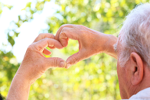 Phoenix Grandpa Making a Heart Sign Using Fingers After Having Carpal Tunnel Treatment in Tolleson AZ