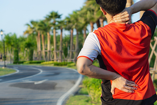 Tolleson Man Walking Along Phoenix AZ Highway In Need of Chiropractor for Neck and Back Pain