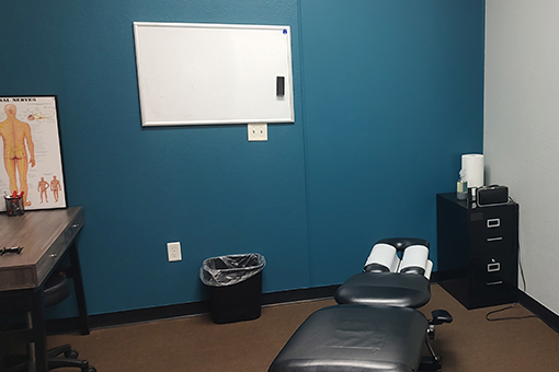 Equipment, Chart. and Bed of a Clinic Near Tolleson and Phoenix AZ Offering Neck Pain Treatment