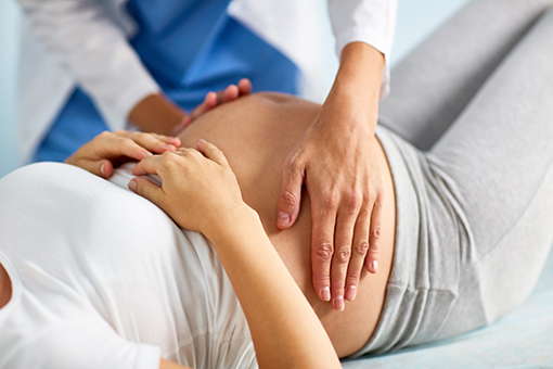 Tolleson Chiropractor Touching Stomach of Pregnant Patient from Phoenix AZ