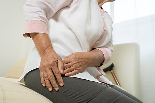 Grandma In Need of Sciatica Treatment Near Tolleson or Phoenix AZ Holding Glutes In Pain