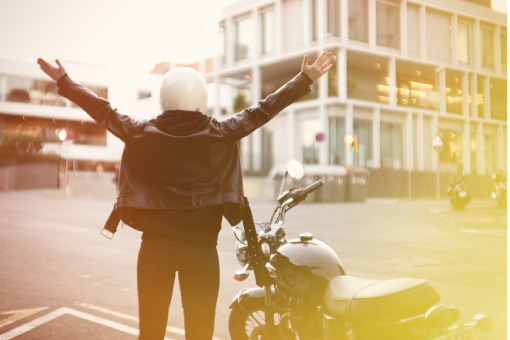 Tolleson Driver Standing Happily Beside Motorcycle After Successful Visit with Chiropractor Helping Her After Accident