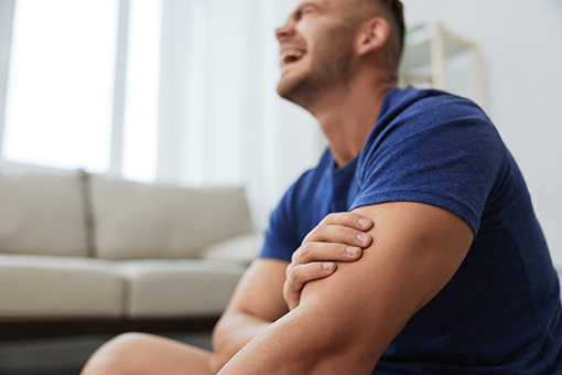 Man Refusing To Go To Personal Injury Chiropractor Touching Arm Hurt in Phoenix Arizona