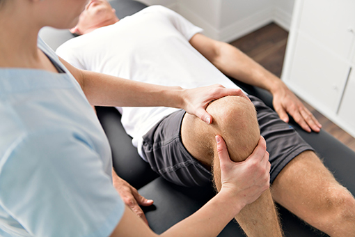 Accident Chiropractor Massaging Knee of a Phoenix AZ Man
