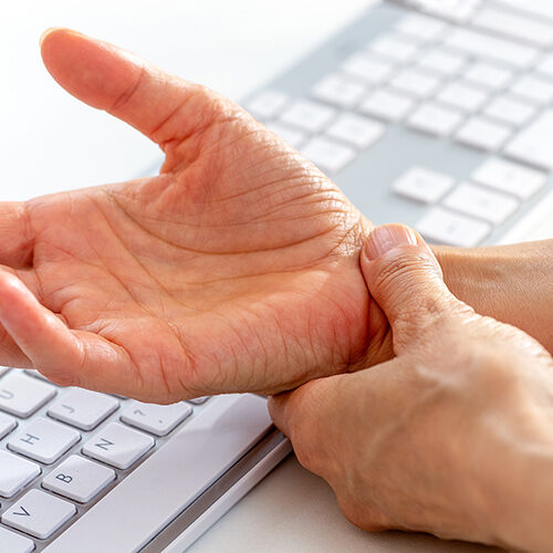 Man Using Keyboard In Need of Chiropractor Near Phoenix or Tolleson AZ Offering Carpal Tunnel Treatment