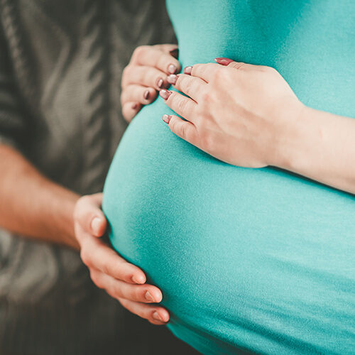 Tolleson Doctor Offering Chiropractic Services Touching Belly of Pregnant Woman from Phoenix AZ